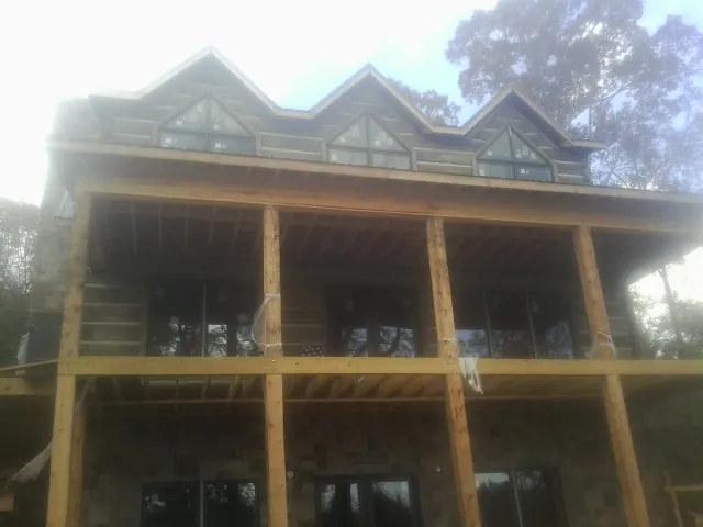Dormers and porch framing on a large log home under construction — Roof Coating work by our crew in Highland Falls