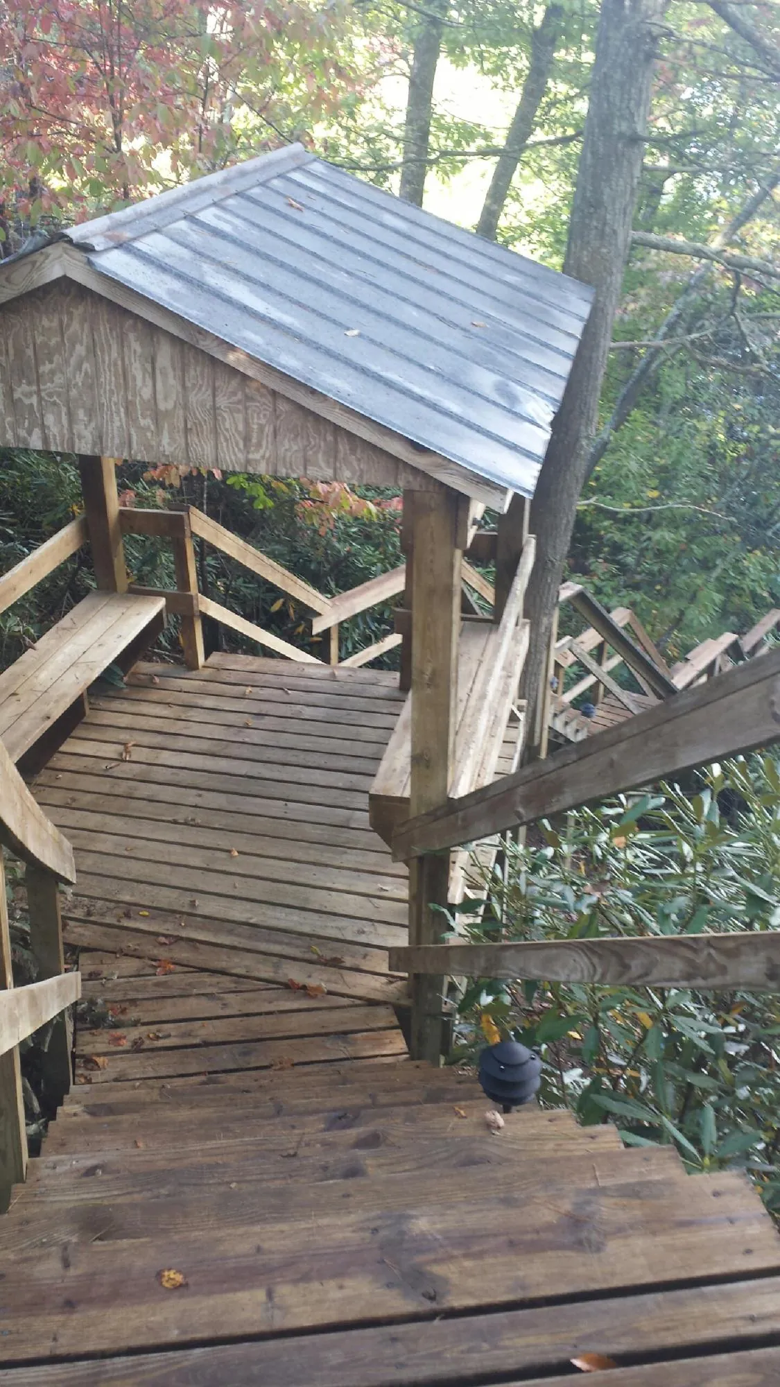 Metal roofed shelter over wooden steps on a wooded walkway — Skylight Repair & Installation work by our crew in Highland Falls